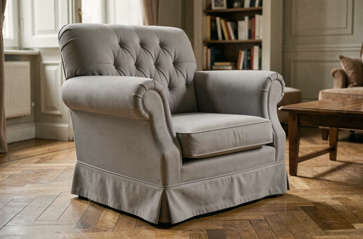Fauteuil club recouvert d'une housse extensible gris tourterelle dans un salon parisien chaleureux avec parquet en chêne